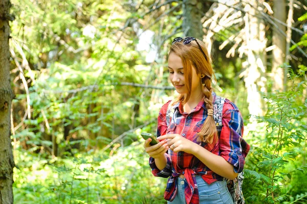 Randonneur jeune fille recherche les coordonnées GPS sur le smartphone  . — Photo