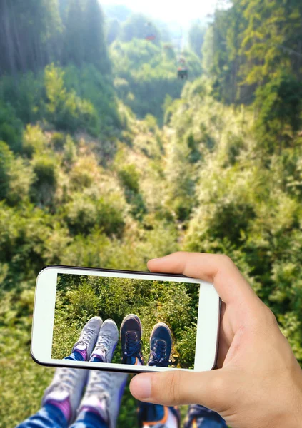 手中的腿与智能手机的照片视图. — 图库照片