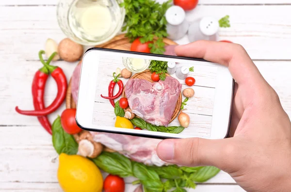 Ręce biorąc zdjęcie surowe mięso z smartphone. — Zdjęcie stockowe