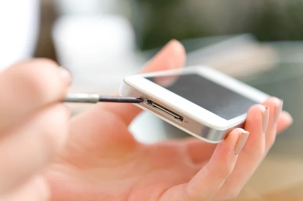 Close-up de telefone celular de reparação de mão humana com chave de fenda na mesa — Fotografia de Stock