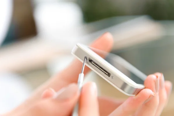 Close-up van menselijke Hand herstellen Cellphone met schroevendraaier op Bureau — Stockfoto