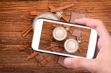 Eller smartphone ile lezzetli sıcak kakao fincan fotoğraf.