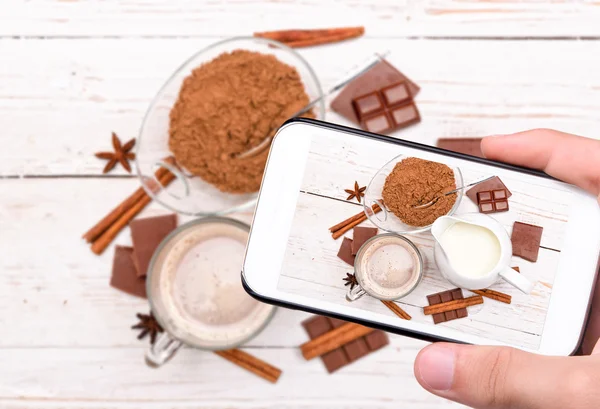 Hände fotografieren Tasse mit leckerem heißen Kakao mit Smartphone. — Stockfoto