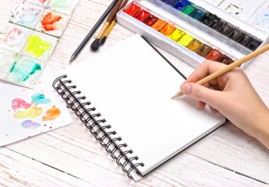 İnsan eli kalem ile not defterinde çizer.