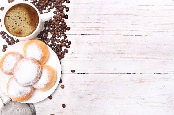 Donuts com xícara de café em uma mesa de madeira . — Fotografia de Stock