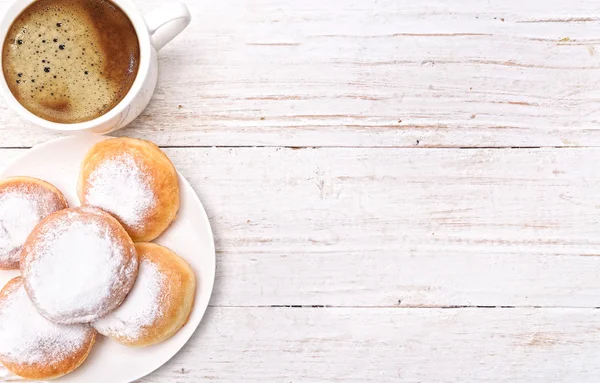 Donuts con taza de café en una mesa de madera . —  Fotos de Stock