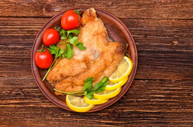 Kızarmış Balık filetosu domates ve limon ahşap bir masa üzerinde ile.