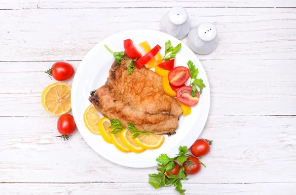 Kızarmış Balık filetosu domates ve limon ahşap bir masa üzerinde ile. — Stok fotoğraf