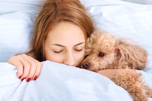 女孩和她的狗躺在床上 — 图库照片