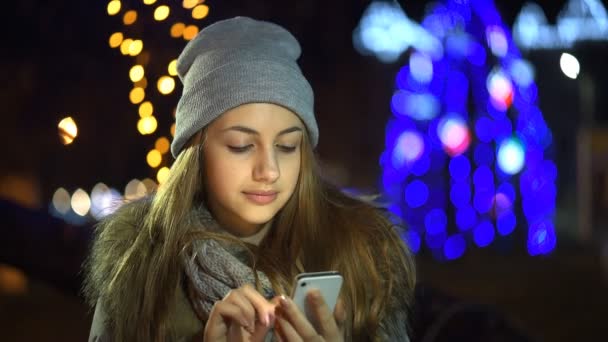 Menina usando um telefone celular ao ar livre . — Vídeo de Stock