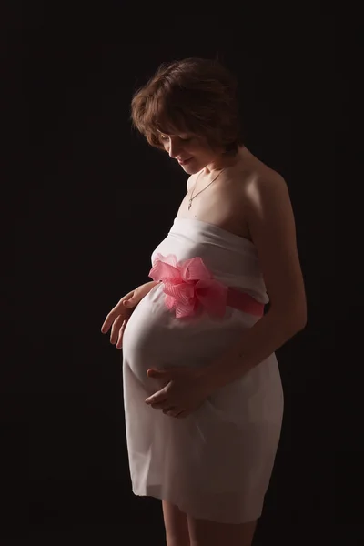 Pregnant woman on the dark background — Stock Photo, Image