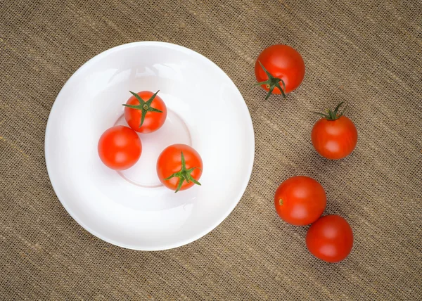 Tomates cereja frescos maduros na placa branca — Fotografia de Stock