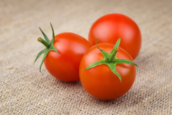 Reife frische Kirschtomaten auf grobem Stoff — Stockfoto