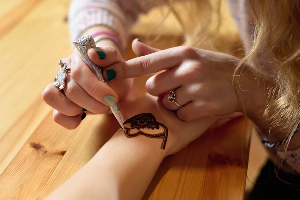 Joven mujer mehendi artista pintura henna en la mano —  Fotos de Stock
