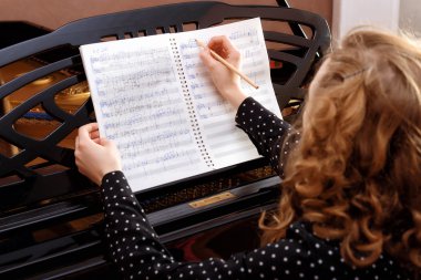 Genç kadın müzisyen müzik kitap kurşun kalemle yazar.