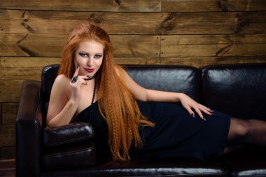 Kanepede poz genç Kızıl saçlı kadın