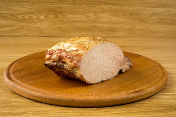 De grote gesneden stuk van gebakken varkensvlees op een tafel. — Stockfoto