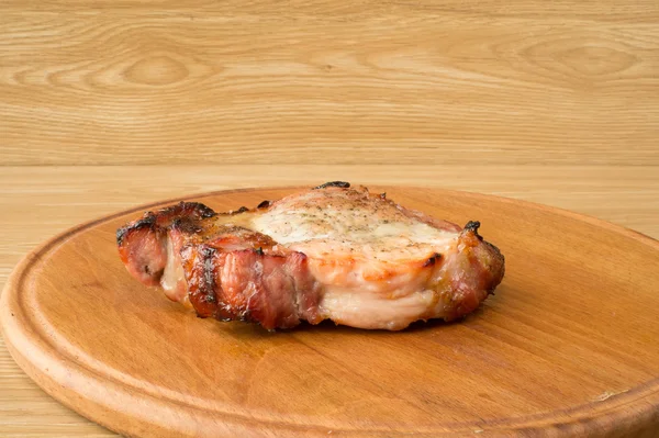 Carne assada por uma grande parte em uma mesa . — Fotografia de Stock