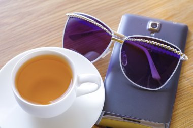 Green tea, sun glasses and the smart phone.