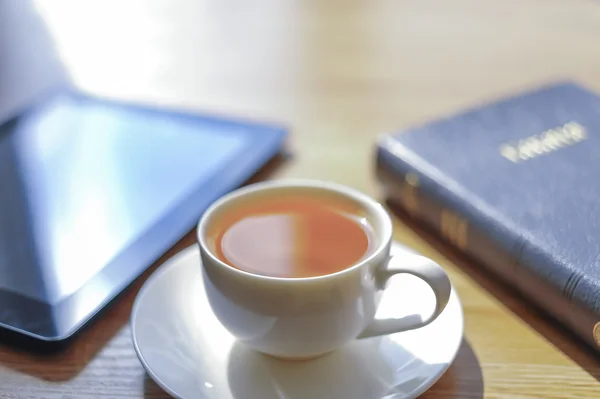 Near a cup the tablet and the Bible lies. — Stock Photo, Image