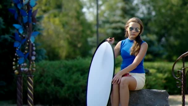 Chica en el parque sostiene un reflector . — Vídeo de stock