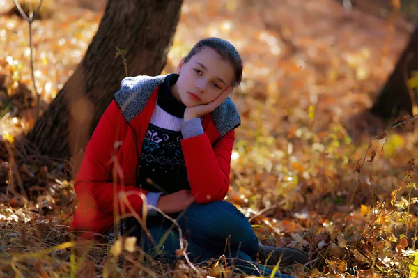 La triste fille est assise sur une herbe d'automne . — Photo