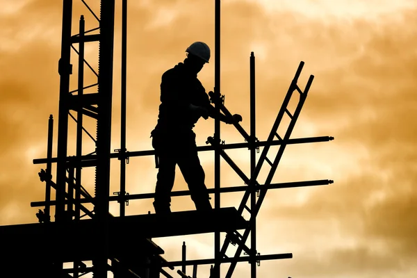 Silhouette byggnadsarbetare på byggnadsställningar byggarbetsplats — Stockfoto