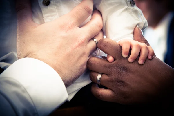 Руки межрасовой пары с ребенком — стоковое фото