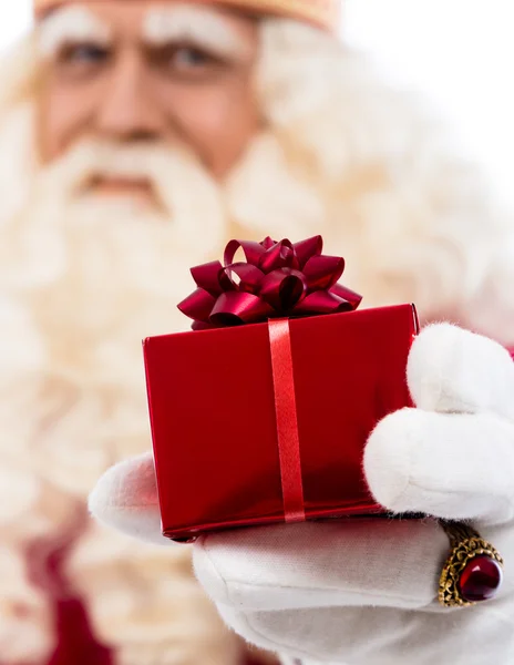 Święty Mikołaj pokazuje prezent — Zdjęcie stockowe