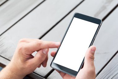 Akıllı cep telefonu ahşap masa arka planda tutan adam