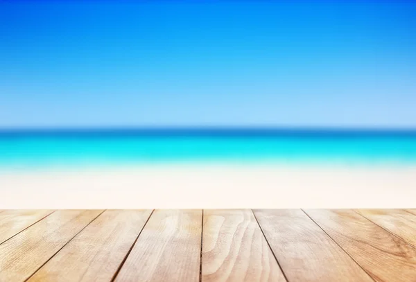 Holztisch auf blauem Meer und weißem Sandstrand — Stockfoto