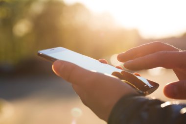 Adam cep telefonunu açık havada kullanıyor, kapat.