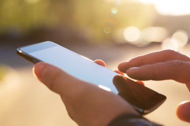 Adam cep telefonunu açık havada kullanıyor, kapat.