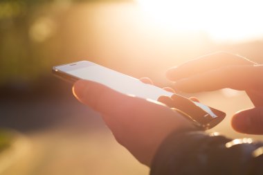 Adam cep telefonunu açık havada kullanıyor, kapat.