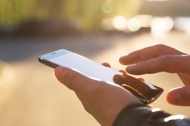 Adam cep telefonunu açık havada kullanıyor, kapat.