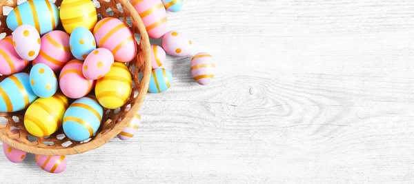 快乐的复活节木制背景与粉红色 黄色和蓝色的蛋 白色木制桌子上有彩蛋的礼券 — 图库照片