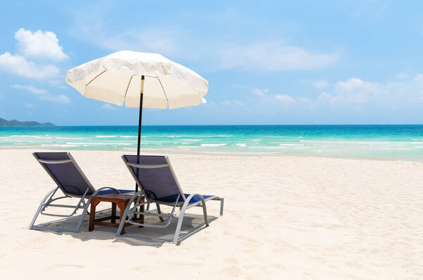 Beach chairs with white umbrella and beautiful sand beach in Koh Samui, Thailand. Vacation holidays summer background. View of nice tropical beach.
