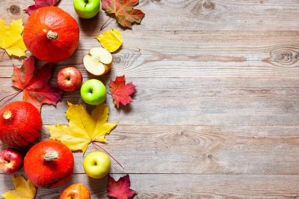 秋天的边界是苹果 南瓜和落在旧木桌上的树叶 感恩节的概念 感恩节南瓜与水果 秋天有南瓜的水果和蔬菜依然生机勃勃 — 图库照片