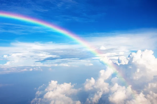 Blue sky with clouds and a rainbow — Stock Photo, Image