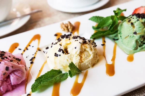 Three scoops of pistachio, strawberry and vanilla ice cream in b — Zdjęcie stockowe