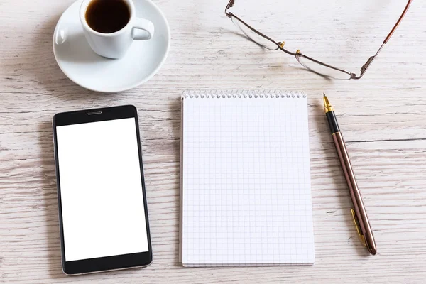 Notebook s chytrý telefon a šálek kávy na dřevěný stůl — Stock fotografie