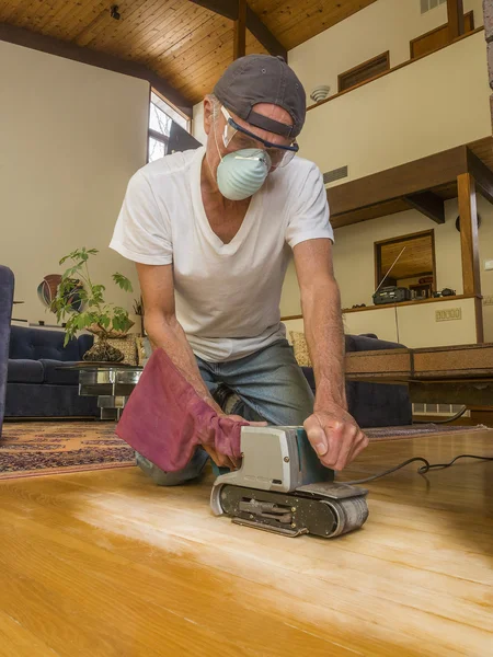 Older man sanding floor — Stock Photo, Image