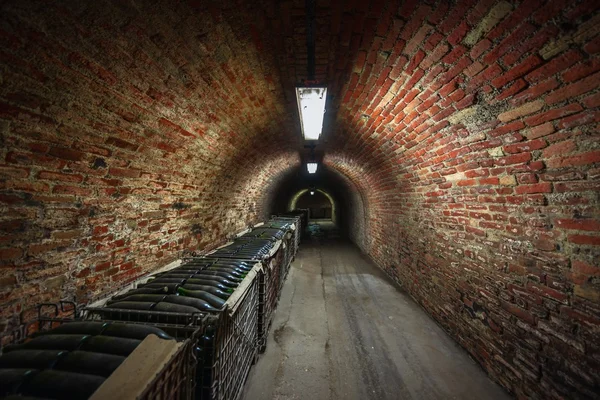 Longo túnel de tijolo subterrâneo na adega — Fotografia de Stock