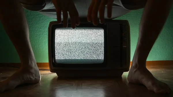 Man sitting on old television — Stock Photo, Image