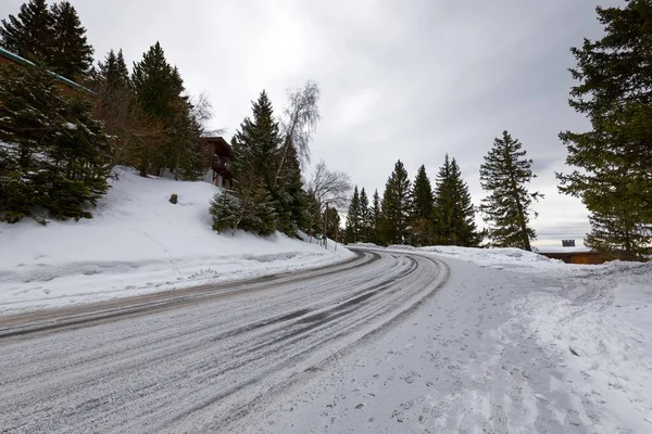 Strada di montagna innevata che attraversa le colline — Foto Stock