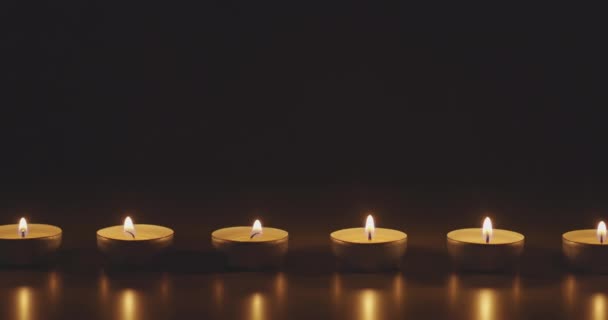 Candles glowing against dark background — Stock Video