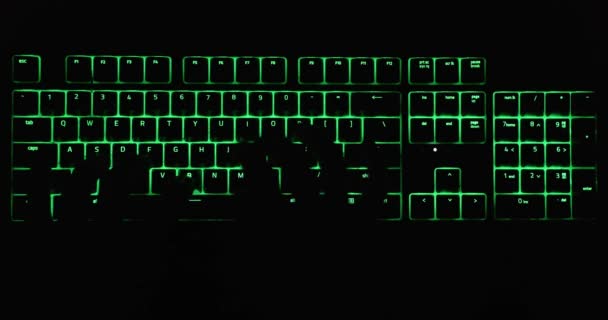 Руки, печатающие в темноте на подсвеченной клавиатуре — стоковое видео