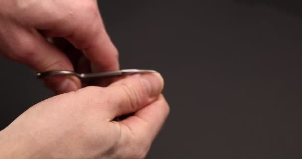 Мужчина стрижет ногти для себя — стоковое видео