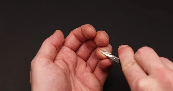 Man Cuts Fingernail Himself Dark Background — Stock Photo, Image