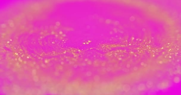 Le particelle dorate si dissolvono in liquido rosa — Video Stock